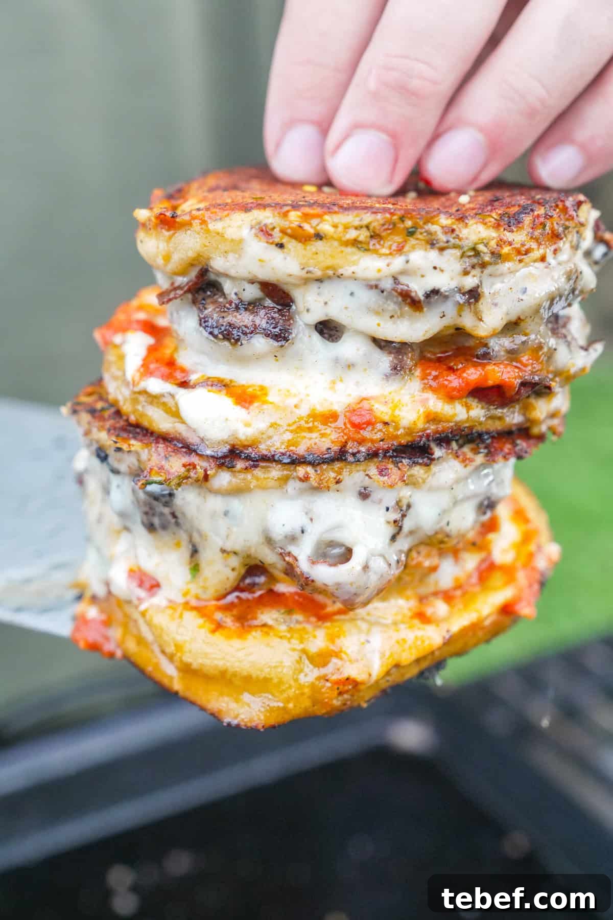 Pizza Smashburger Recipe: Crispy Beef Patty with Melty Pizza Toppings 8 A stack of two pizza smashburgers with mozzarella cheese, beef patties, pizza sauce, garlic aioli and garlic Parmesan butter