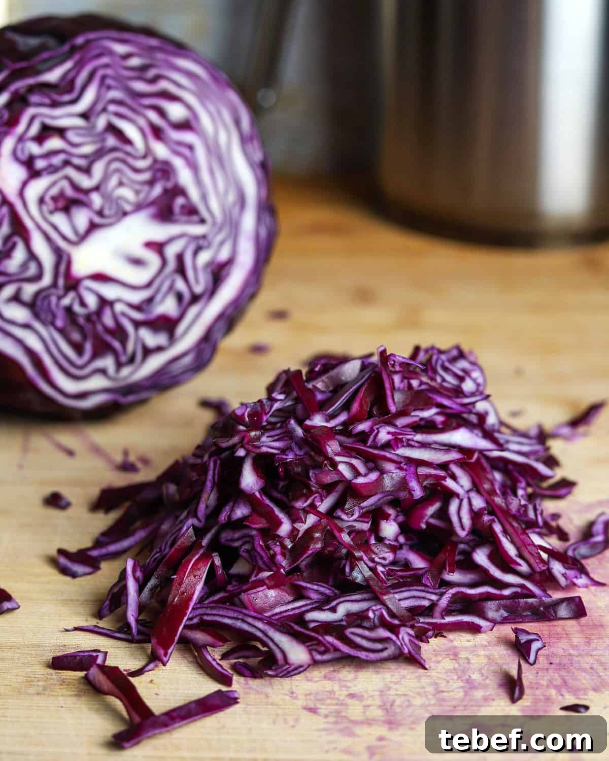 Photo of a pile of sliced red cabbage on a chopping board.