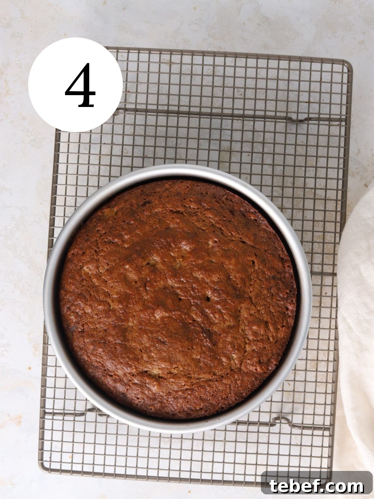 Moist Banana Olive Oil Cake Recipe for Perfect Homemade Dessert 7 A banana cake in a pan set on a baking rack.
