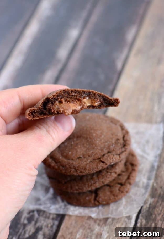 Check out the caramel filling in these Rolo Cookies. Trust me, you want to make these chocolate caramel cookies! #rolocookies #caramelfilledcookies #chocolatecaramelcookies - from creationsbykara.com caramel stuffed cookie broken in half