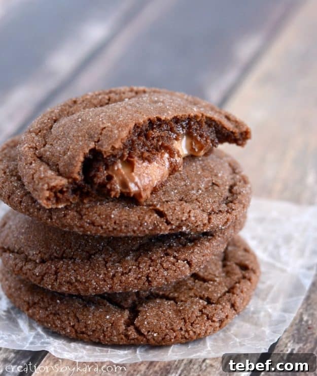 Watch out, these Chocolate Rolo Cookies are addicting! You can't beat a chocolate cookie with an ooey gooey caramel center! #rolocookies #caramelfilledcookies #chocolatecaramelcookies #chocolaterolocookies - from creationsbykara.com stack of chocolate rolo cookies with one broken in half