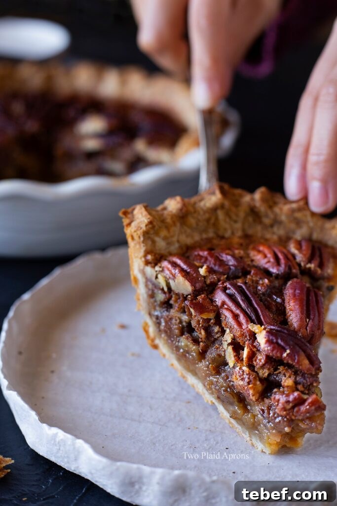 Placing a slice of maple syrup pecan pie onto a white plate.