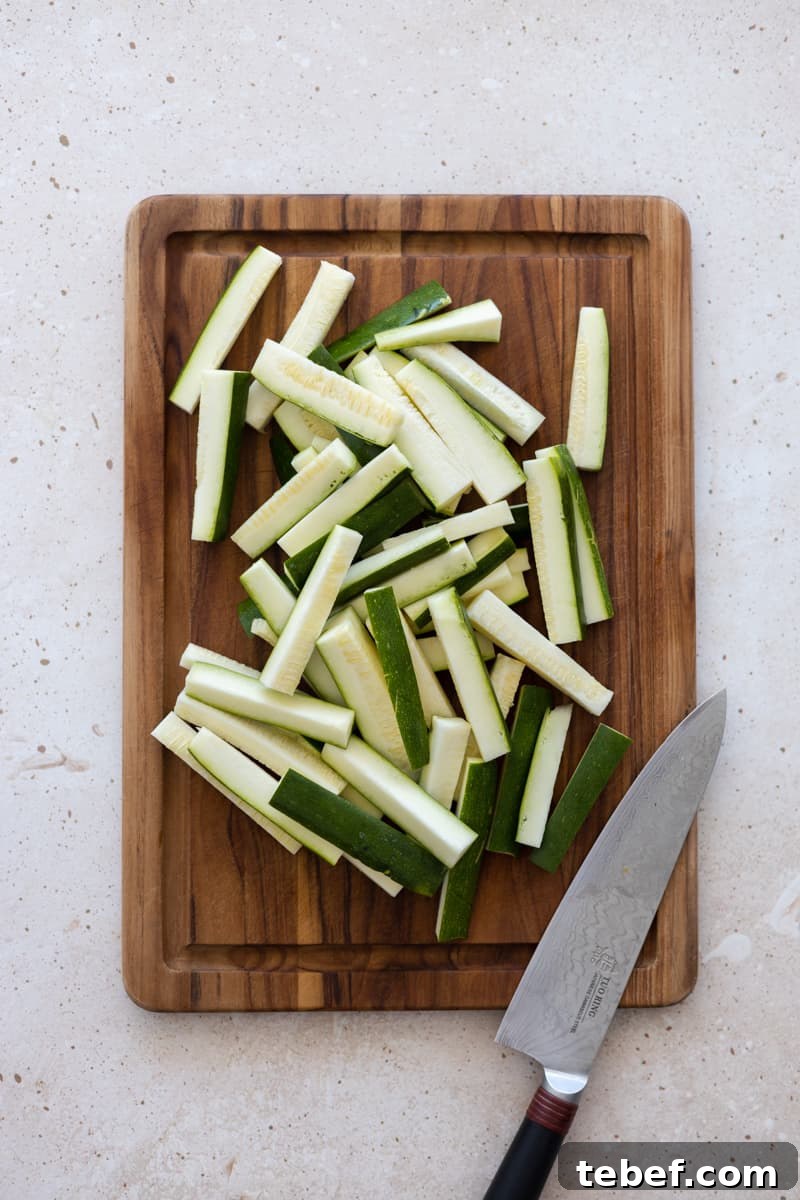 Cut zucchini slices on a wooden cutting board. 