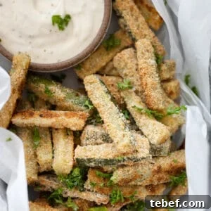 A closeup of baked zucchini sticks in a basket.