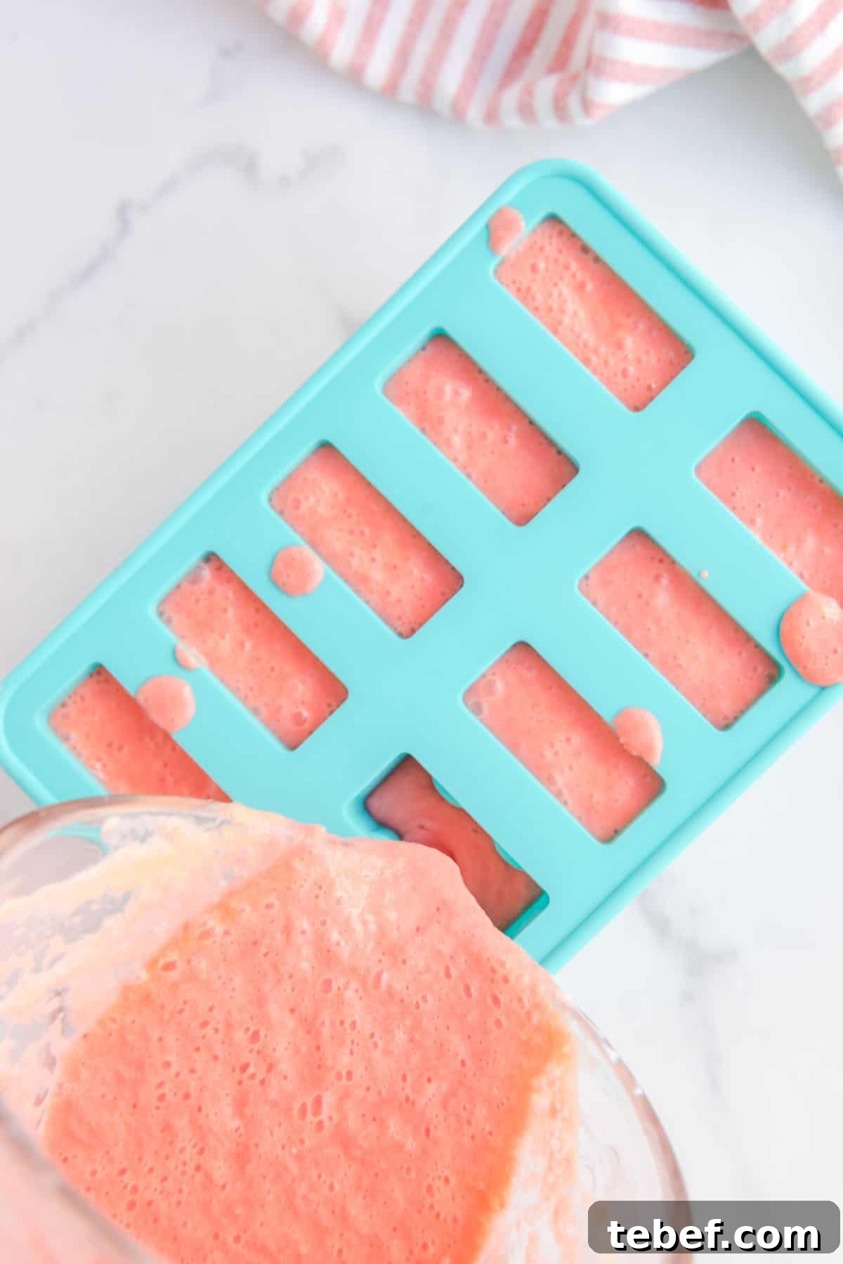 Refreshing Watermelon Popsicle Recipe: 3-Ingredient Frozen Treats 8 Overhead shot of blended popsicle ingredients being poured in the popsicle mold.