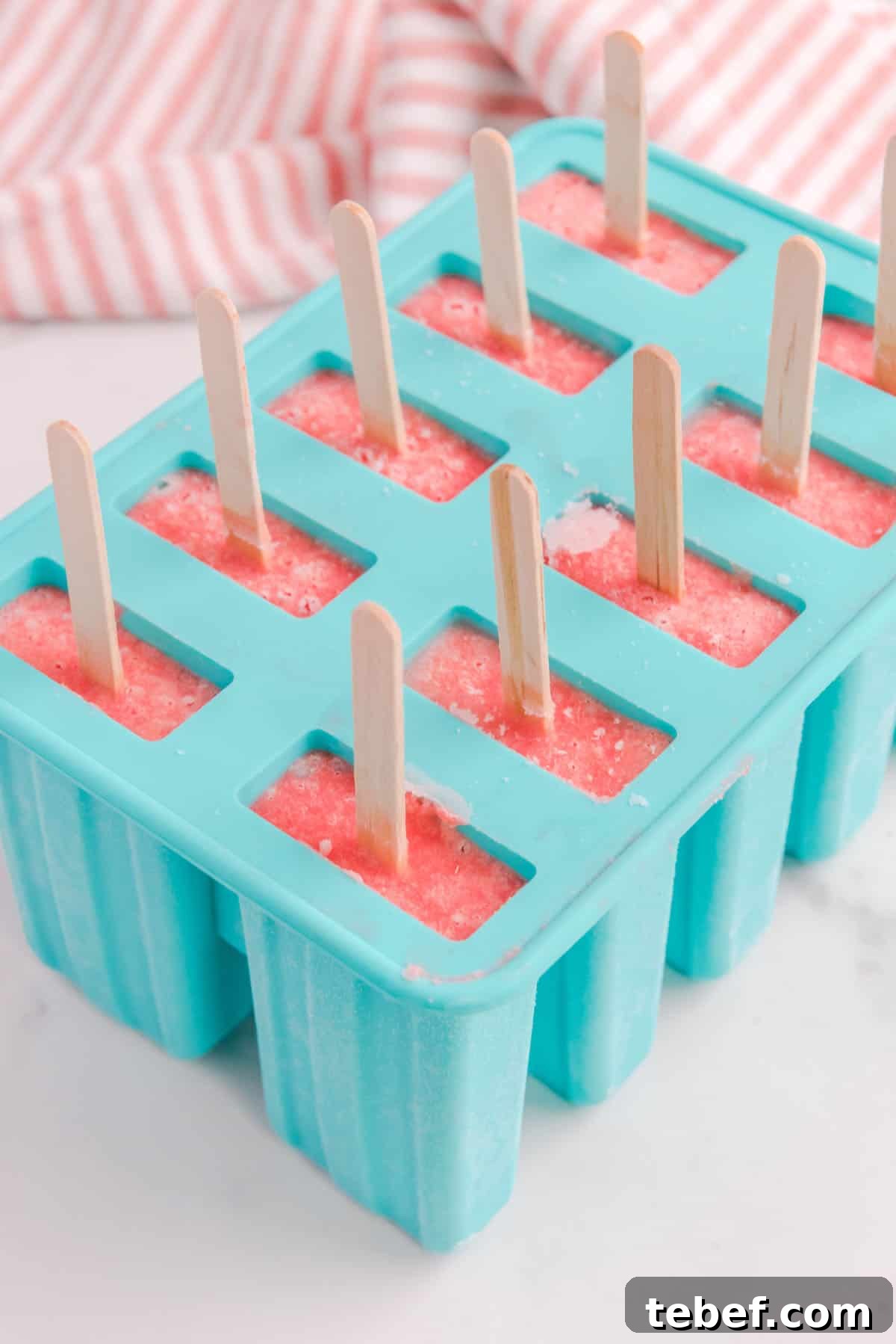 Refreshing Watermelon Popsicle Recipe: 3-Ingredient Frozen Treats 9 Ten watermelon popsicles with sticks in the popsicle mold.