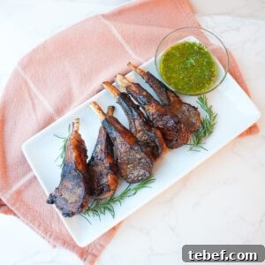 Garlic Herb Lamb Chops with Crispy Seared Edges 8 Lamb chops with a side of mint chimichurri on a plate with visible herbs and a glossy seared crust.