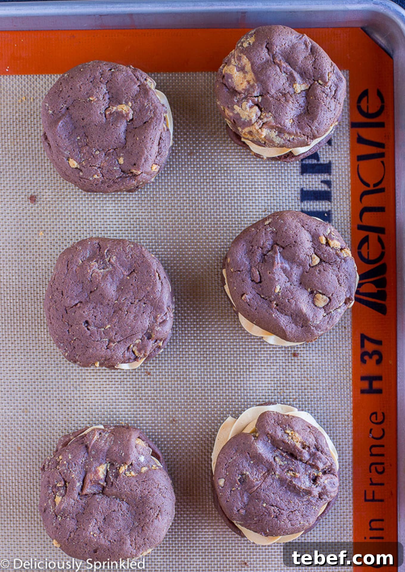 Overhead shot of peanut butter whoopie pies on a silpat mat.
