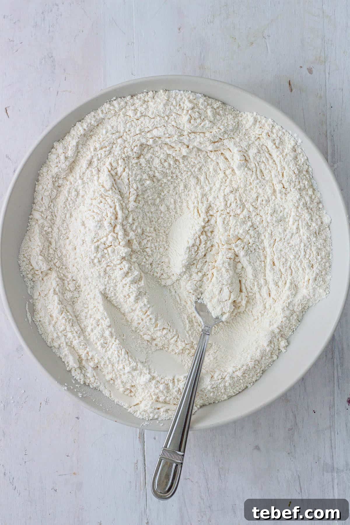 Flour, baking powder, baking soda, salt and sugar in a mixing bowl.