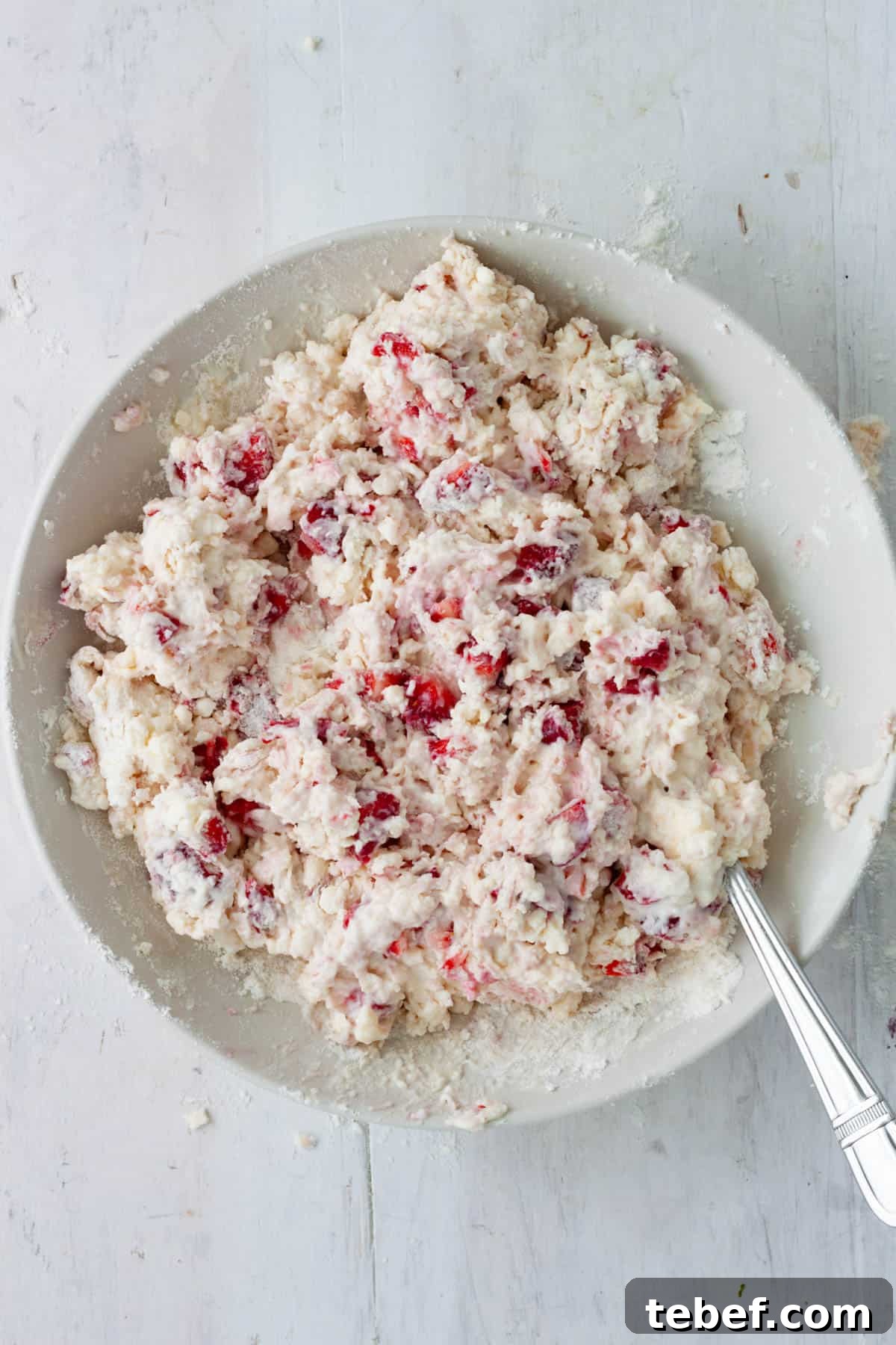 Strawberry biscuit dough in a medium mixing bowl.
