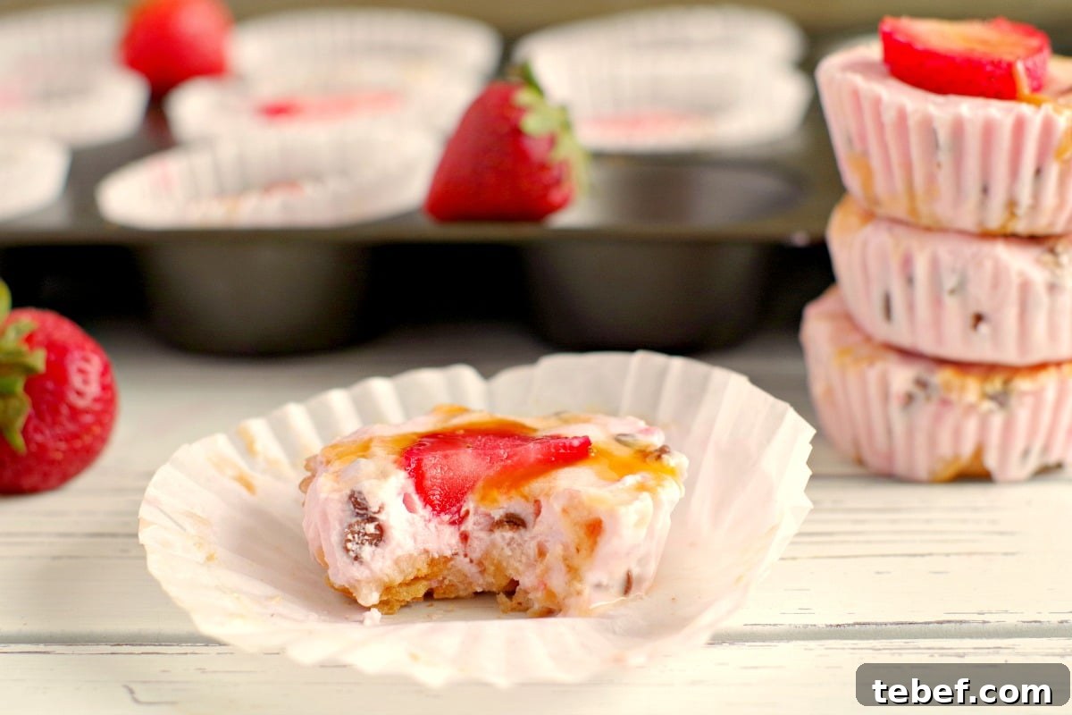Strawberry Drumstick frozen yogurt cup that's been bit into on wrapper with muffin pan in background