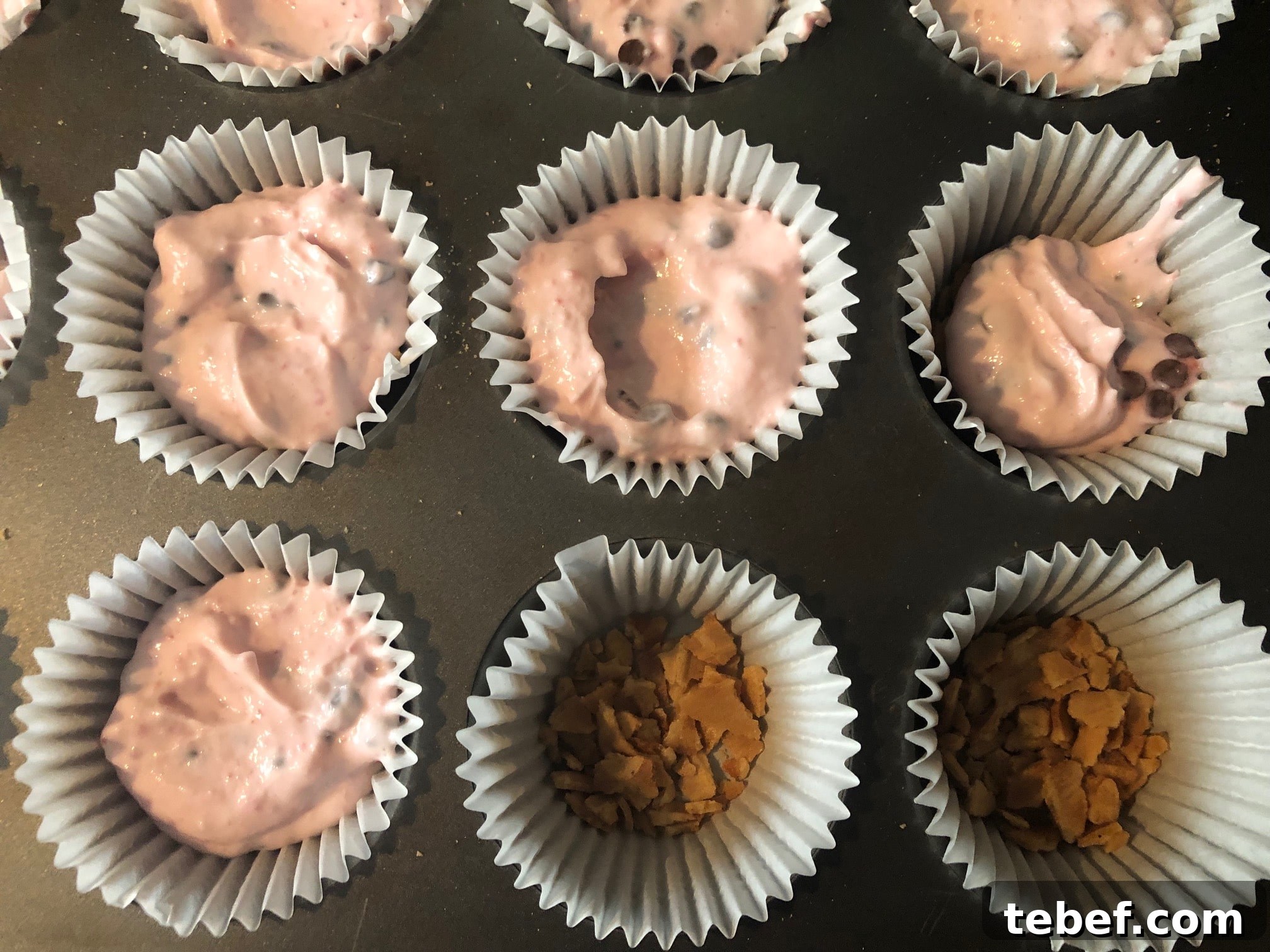 Filling up muffin cups with strawberry yogurt mixture
