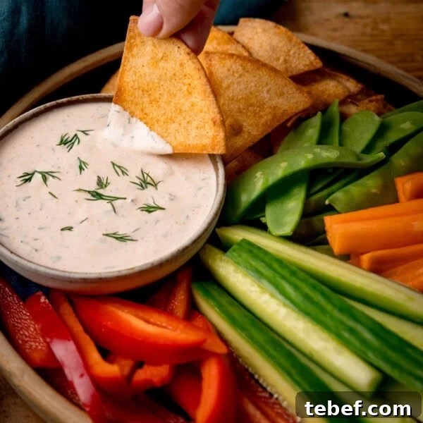 Creamy Beer Cheese Dip Recipe for Game Day and Parties 6 A square shot of a small dish of buffalo ranch dressing with dipping vegetables.