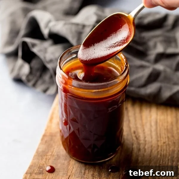 Creamy Beer Cheese Dip Recipe for Game Day and Parties 7 Spoonful being taken from a jar of homemade bbq sauce.