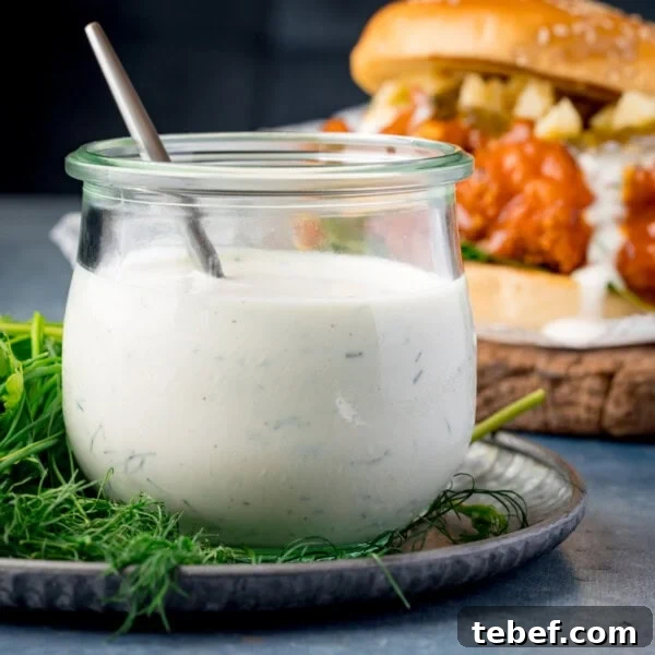 Creamy Beer Cheese Dip Recipe for Game Day and Parties 9 Jar of homemade ranch dressing with a spoon.