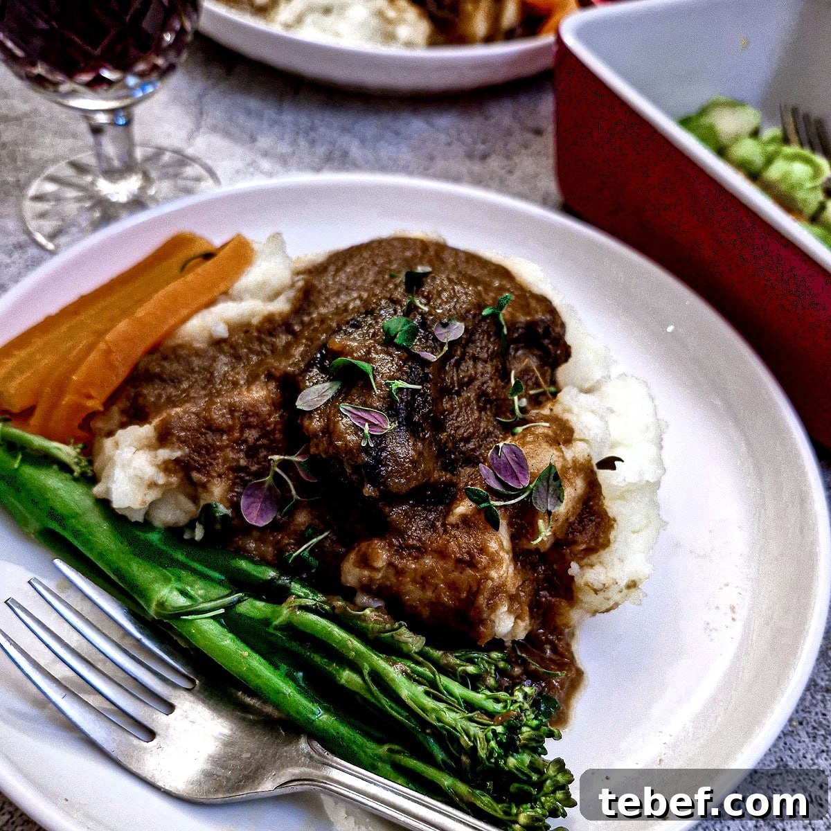 Melt-in-Your-Mouth Slow-Braised Beef Cheeks Recipe 3 Slow-braised beef cheek on mashed potatoes with steamed broccoli and carrots.