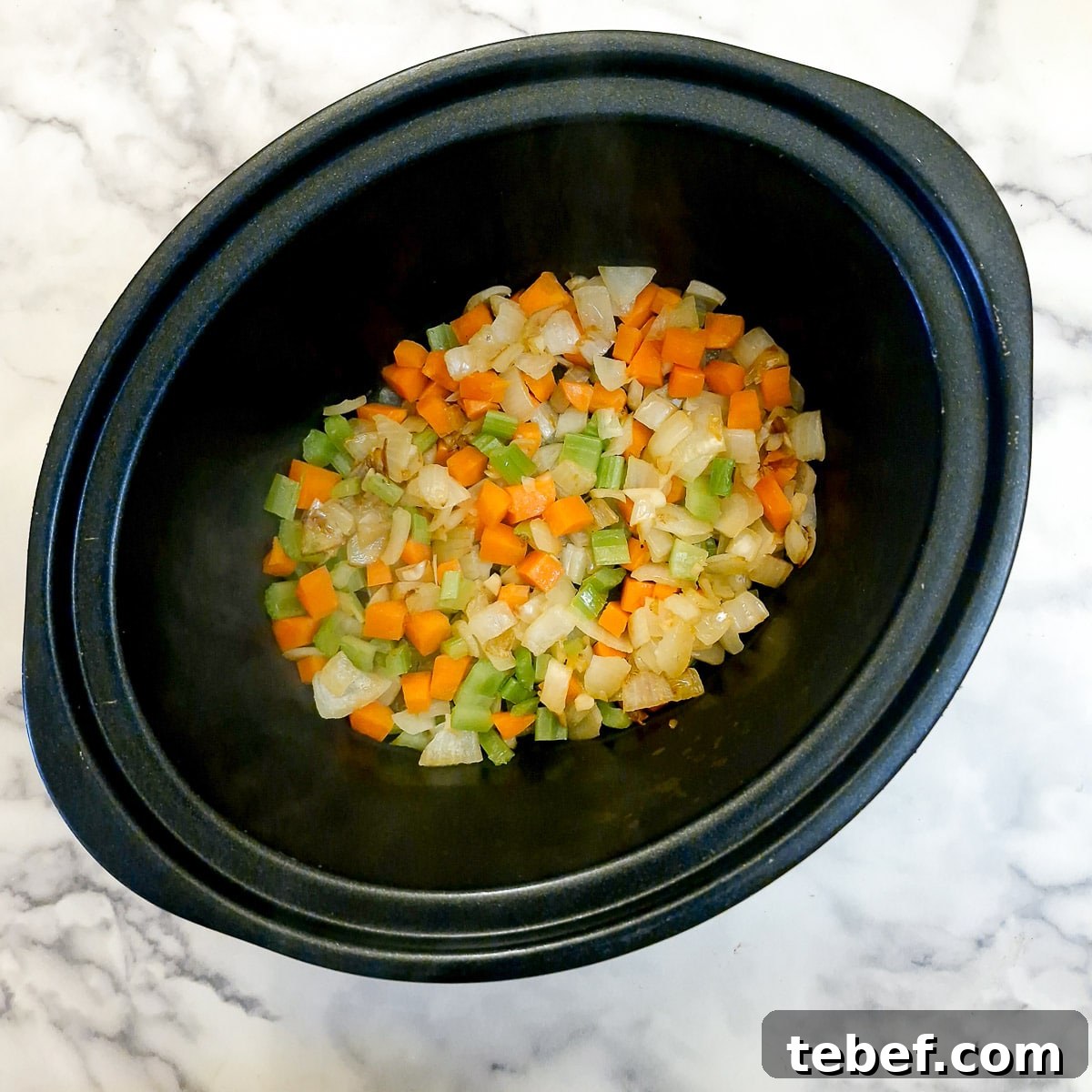 Melt-in-Your-Mouth Slow-Braised Beef Cheeks Recipe 7 Softened vegetables in a slow cooker.