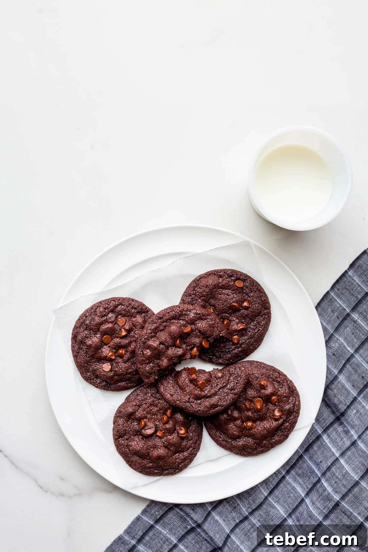 Double Chocolate Chip Cookie Recipe for Rich, Chewy Cookies 2 A plate of double chocolate chip cookies with a glass of milk.