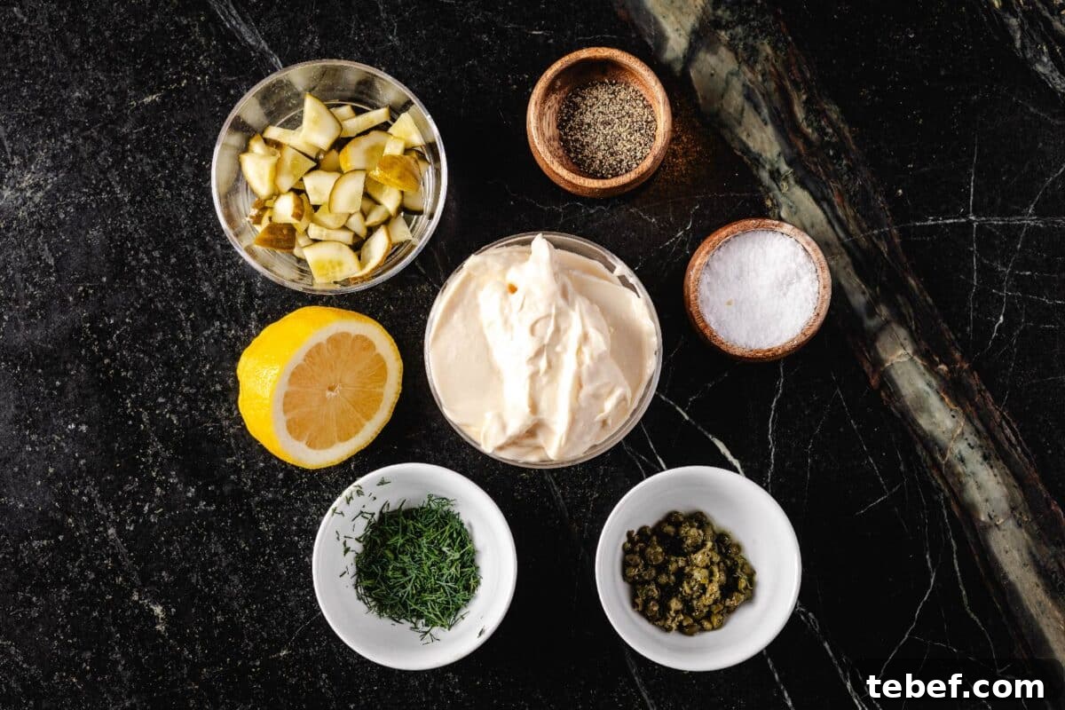 Creamy Dill Tartar Sauce Recipe for Seafood & Sandwiches 3 Glass bowls with mayo, dill, and various seasonings on a marble countertop.