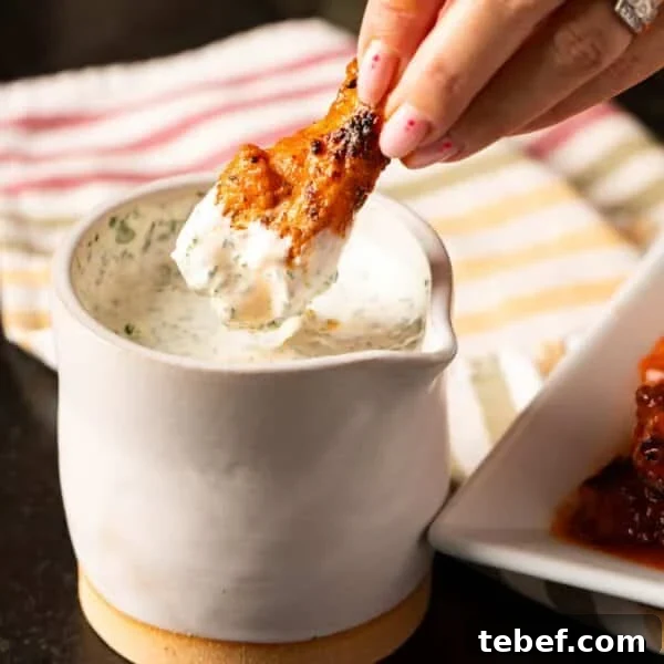 Creamy Dill Tartar Sauce Recipe for Seafood & Sandwiches 8 Buffalo wing being dipped into jar of dipping sauce.