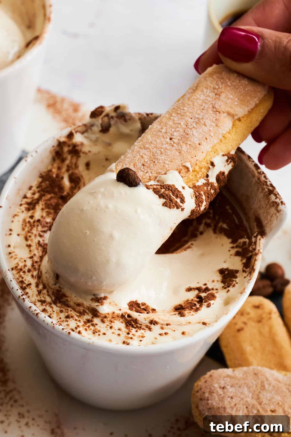 Tiramisu Dessert Dip Recipe for Coffee Lovers 2 A ladyfinger cookie being dipped into a bowl of tiramisu dip.