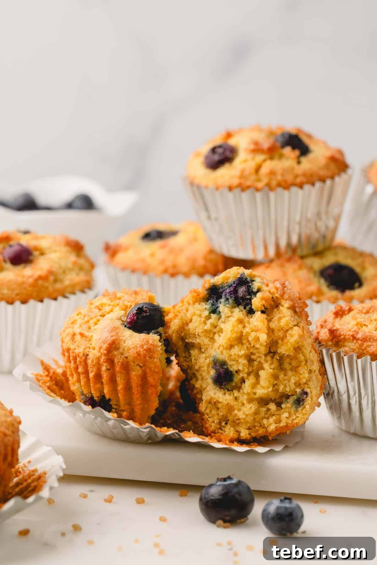 Almond Flour Blueberry Muffins Recipe — Moist Low-Carb Muffins 14 An almond flour blueberry muffin split in half on top of a muffin liner.