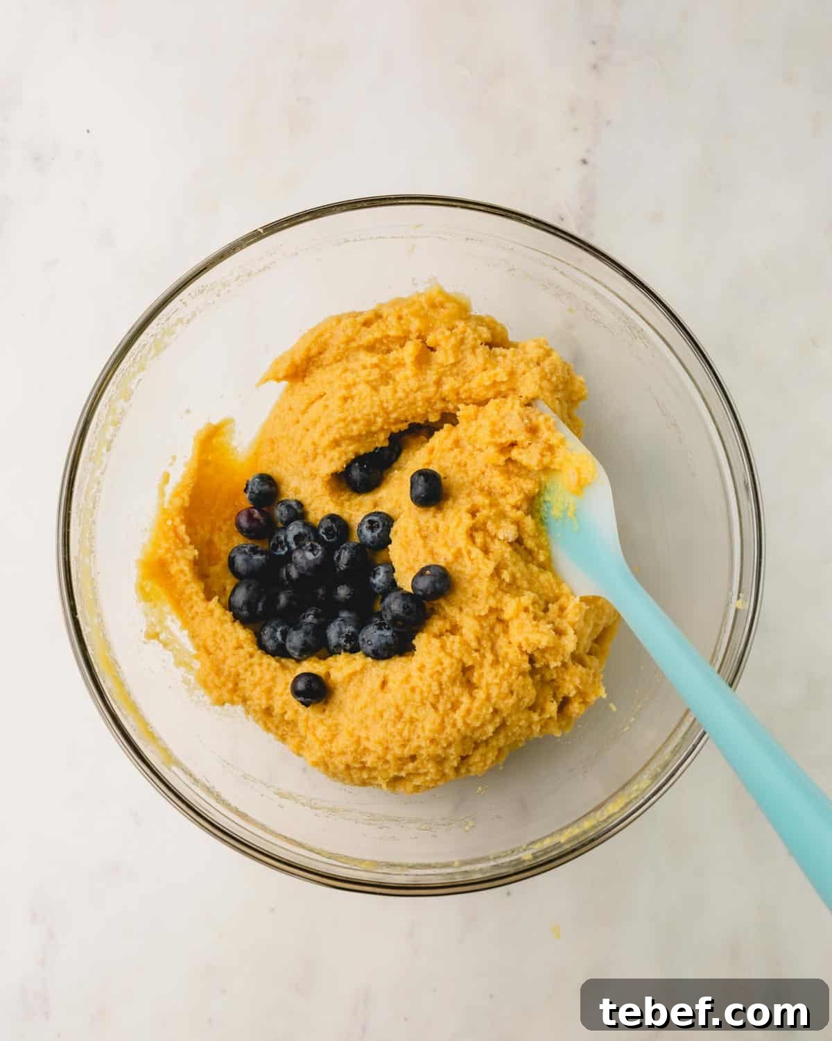 Almond Flour Blueberry Muffins Recipe — Moist Low-Carb Muffins 9 Blueberries being folded into almond flour muffin batter.