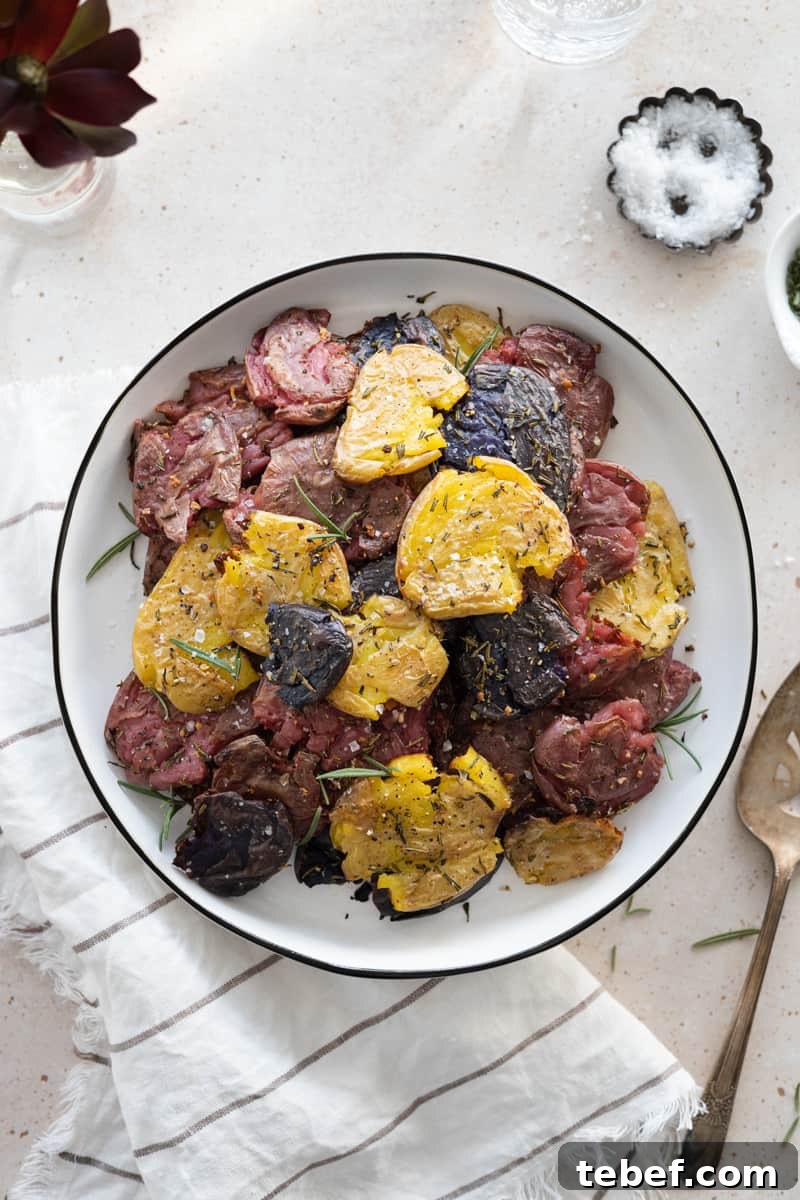Garlic Rosemary Smashed Fingerling Potatoes Recipe 2 Smashed Fingerling Potatoes with Garlic and Rosemary on a white platter with white linen.