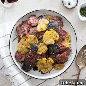 Garlic Rosemary Smashed Fingerling Potatoes Recipe 11 Smashed fingerling potatoes on a white platter.