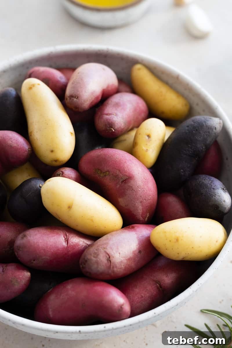 Garlic Rosemary Smashed Fingerling Potatoes Recipe 4 Fingerling potatoes in a white bowl.