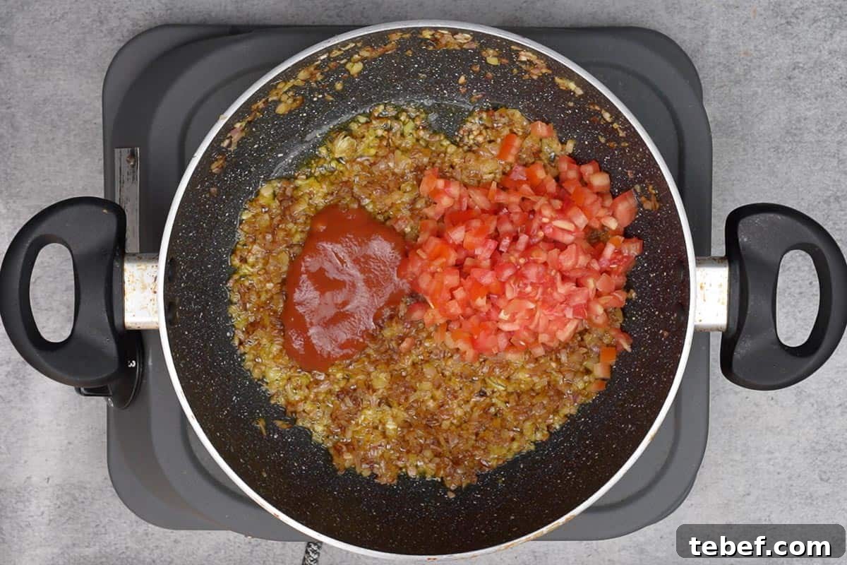 Punjabi Rajma Masala Recipe: Classic Spiced Kidney Beans 8 Chopped tomatoes and tomato puree added to the pan.