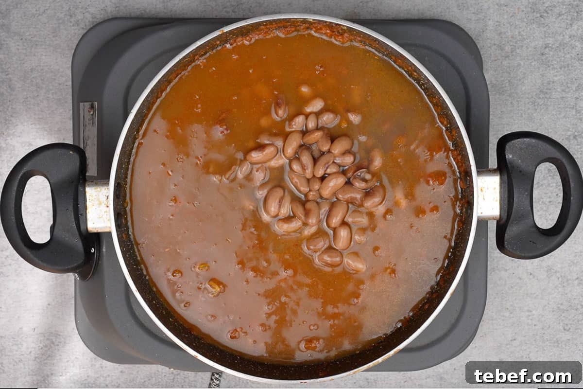 Punjabi Rajma Masala Recipe: Classic Spiced Kidney Beans 10 Cooked rajma along with the water added to the pan.