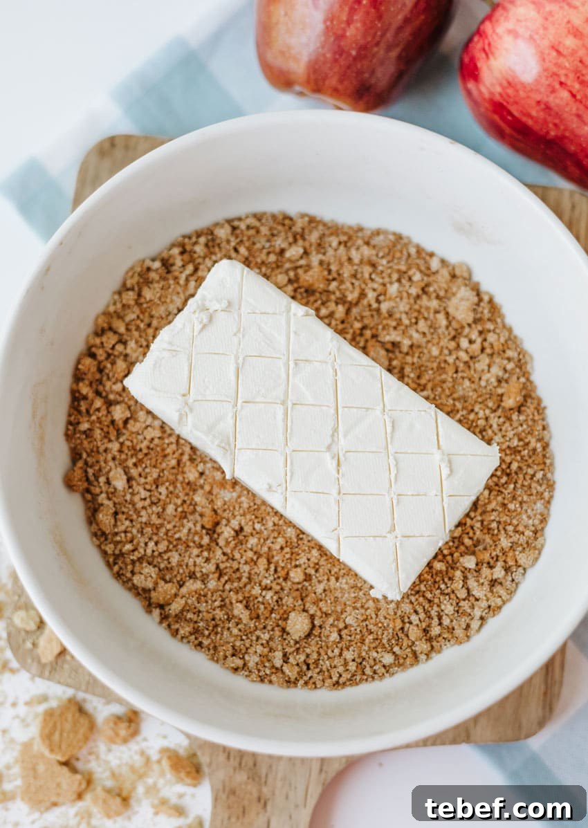 Smoked Cream Cheese with Apple Pie Flavor: Recipe & Tips 5 a scored bar of cream cheese in a bowl of spiced cracker crumbs