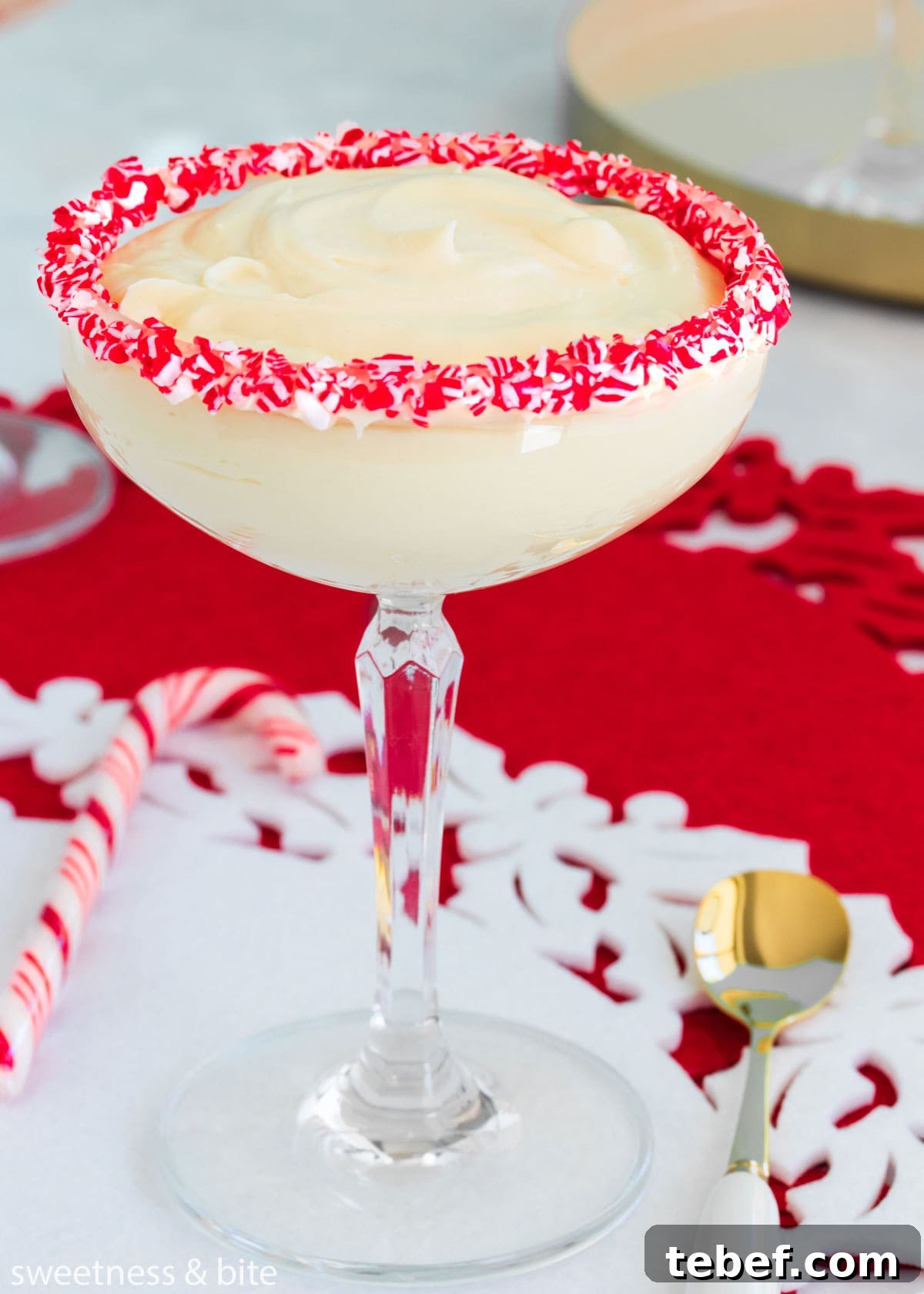 Creamy Peppermint Mousse Recipe for Festive Desserts 3 White chocolate peppermint mousse in a stemmed cocktail glass with crushed candy canes around the rim.