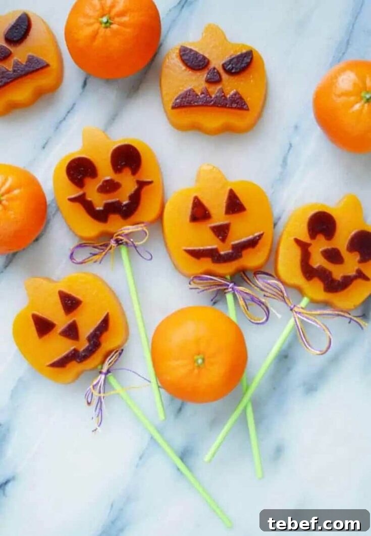 Several finished fruit snacks on marble, with whole, unpeeled clementines intermingled.
