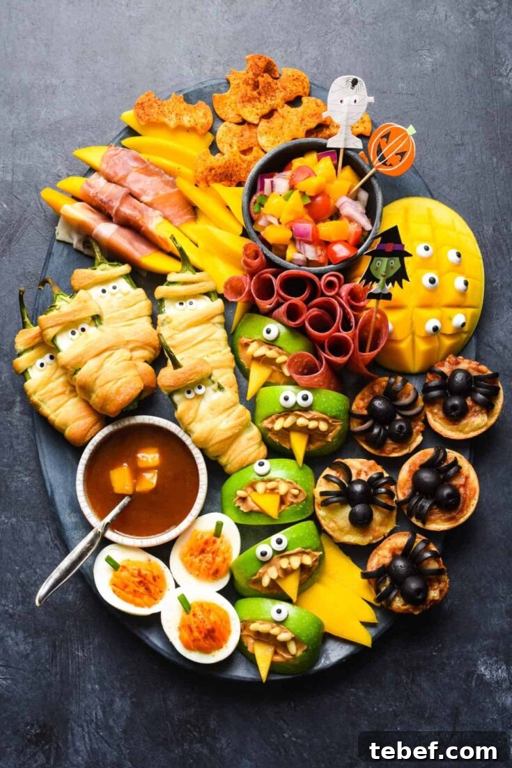 Snack Board on black background with decorative Halloween picks tucked into the fruit salsa.