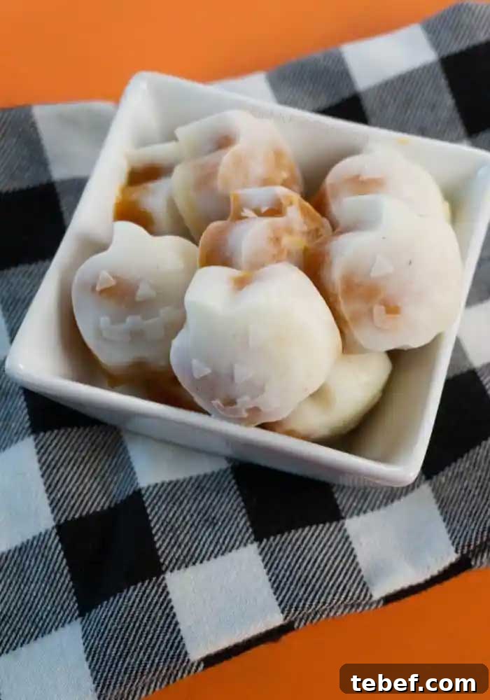 Small square, white dish filled with Pumpkin Bites, on black-and-white checked cloth on orange background.