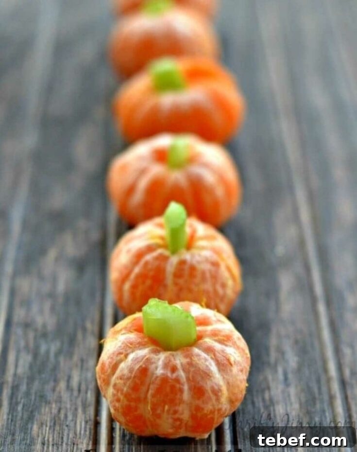 Vertical row of 6 clementine pumpkins on wooden table.