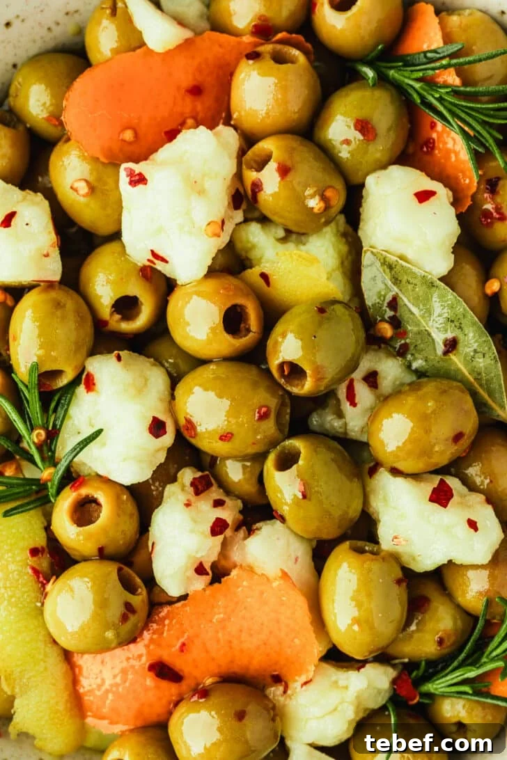 Citrus-Marinated Spanish Olives with Manchego Cheese 6 Marinated Spanish olives with manchego, orange peels, lemon peels, and rosemary sprigs.
