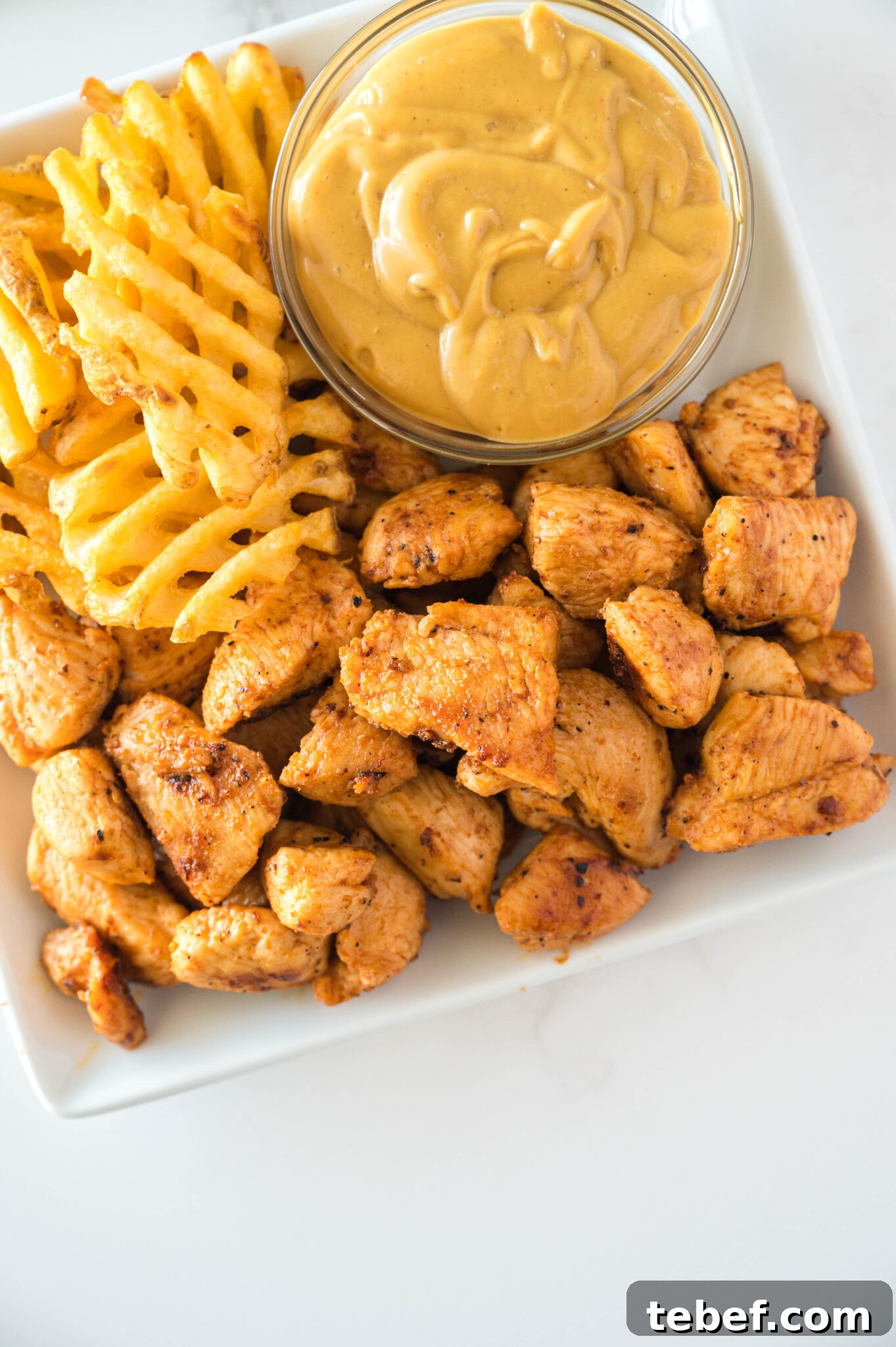 Copycat Chick-fil-A Grilled Nuggets Recipe: How to Make Them at Home 11 Copycat Chick-Fil-A grilled nuggets on a plate with a sauce and fries
