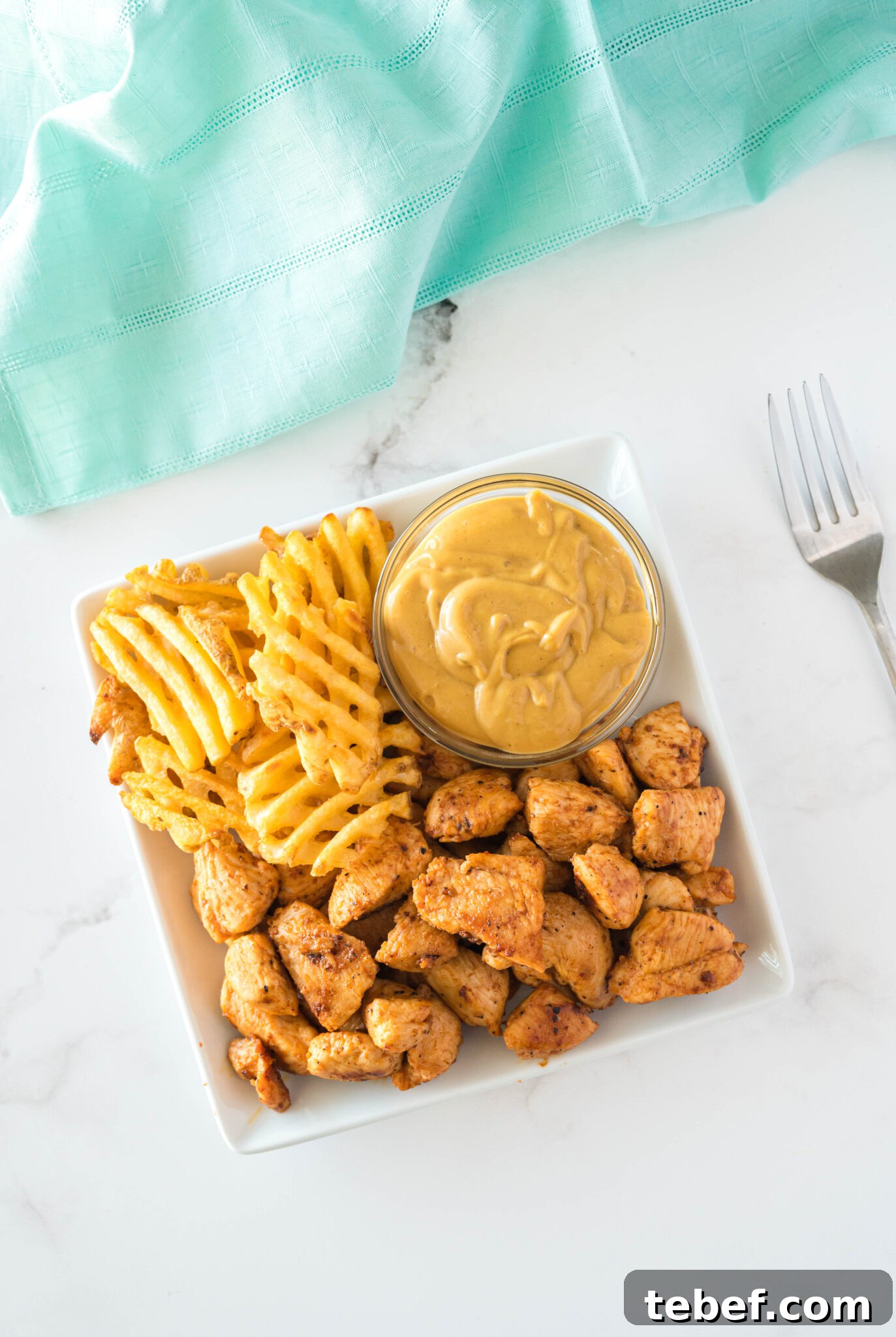 Copycat Chick-fil-A Grilled Nuggets Recipe: How to Make Them at Home 5 Copycat Chick-Fil-A grilled nuggets on a plate with a sauce and fries