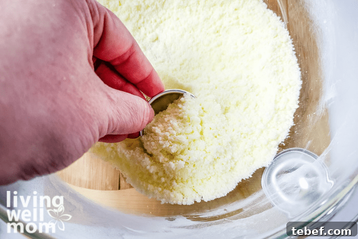 DIY Ultra-Hydrating Coconut Bath Bombs for Silky Skin 9 Coconut mixture being scooped into a mold.