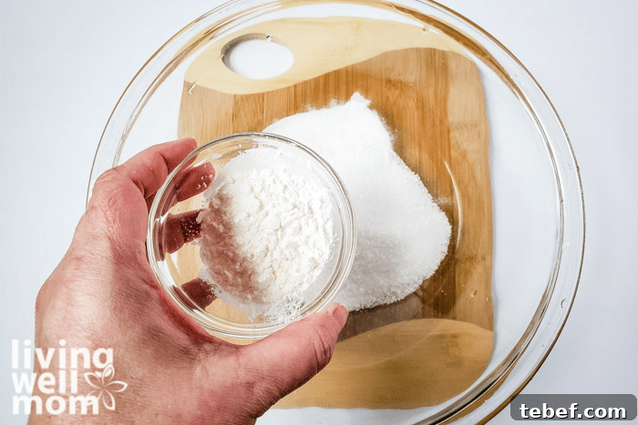 DIY Ultra-Hydrating Coconut Bath Bombs for Silky Skin 7 Corn starch being added into dry ingredients for homemade bath bombs.