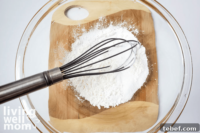 DIY Ultra-Hydrating Coconut Bath Bombs for Silky Skin 8 A whisk sitting in a bowl of DIY coconut bath bomb mixture.