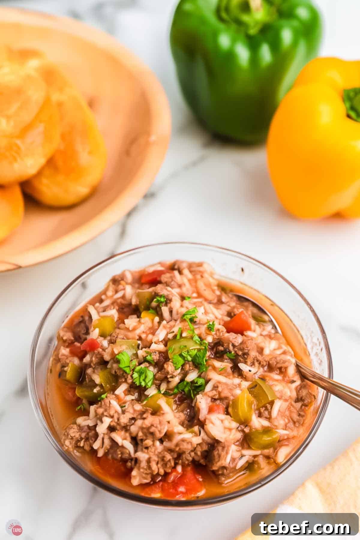 Slow Cooker Stuffed Pepper Soup Recipe for Comforting Weeknights 9 bowl of stuffed bell pepper soup with plate of bread behind it