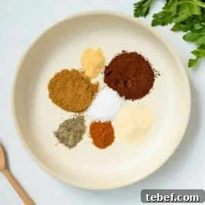Homemade Chili Seasoning Mix Recipe for Authentic Flavor 2 Spices for chili seasoning in cream bowl made with chili seasoning, onion powder, garlic powder, pepper, cumin, salt, and cayenne.