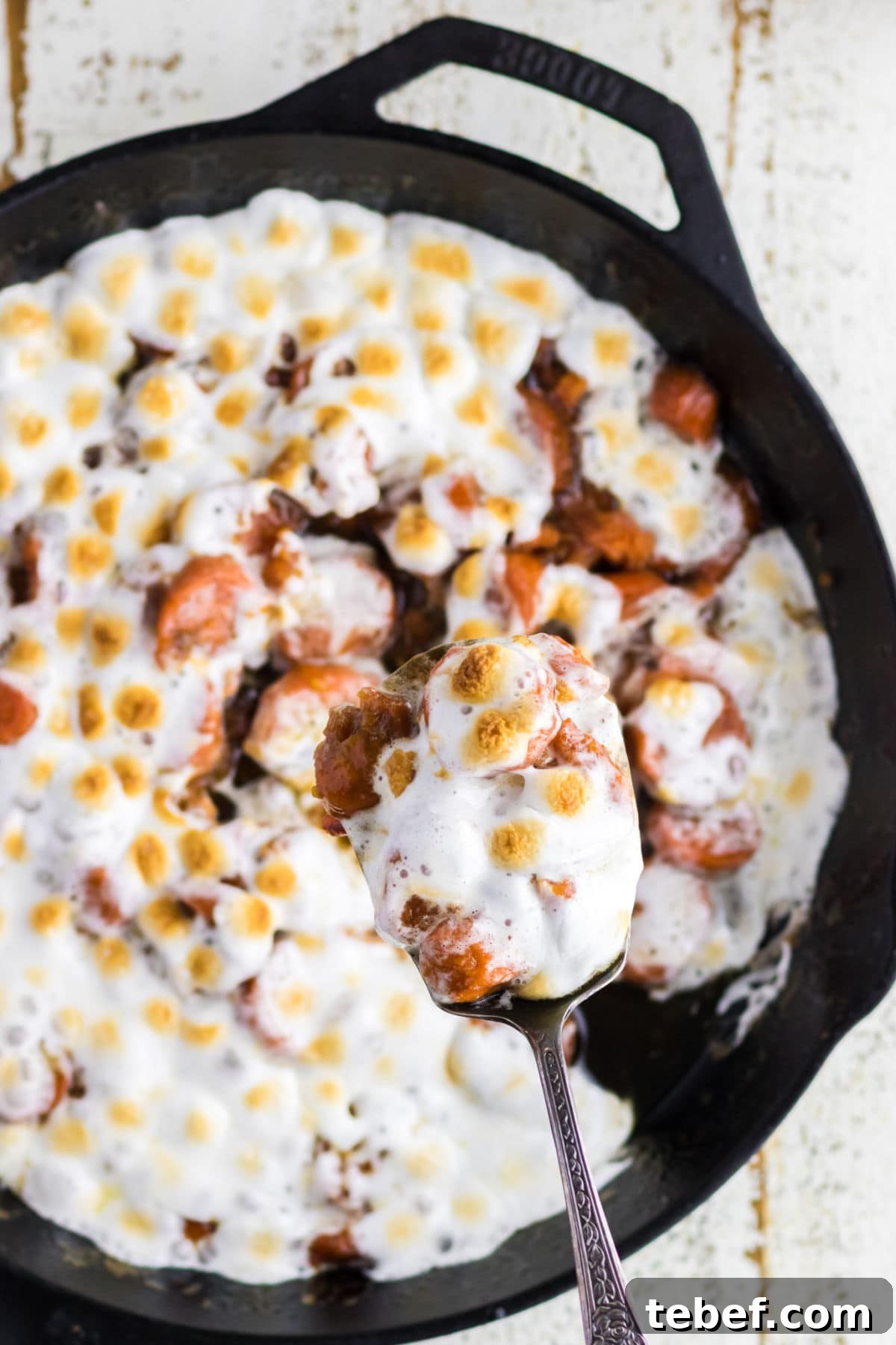 Southern Candied Yams Recipe with Brown Sugar and Pecans 2 Serving of candied yams being removed from skillet.