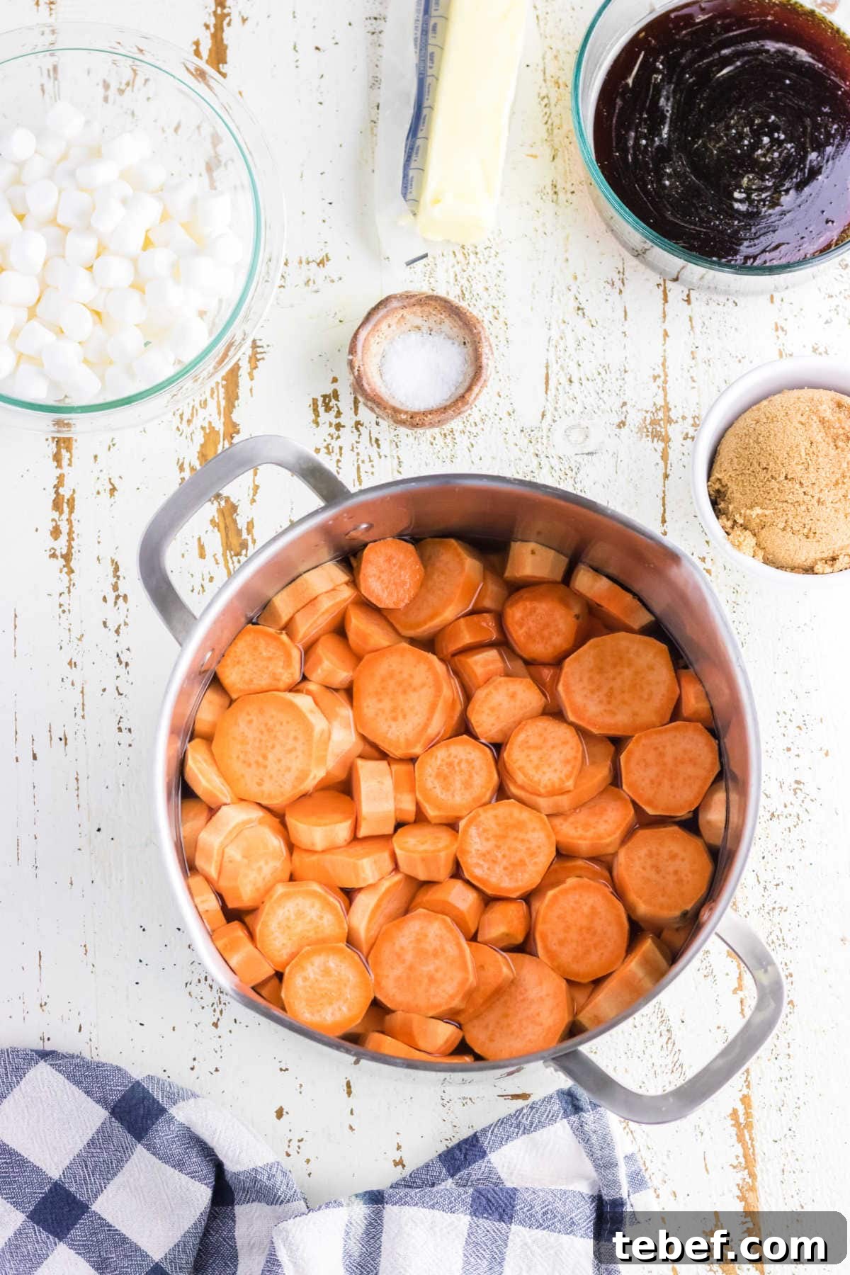 Southern Candied Yams Recipe with Brown Sugar and Pecans 4 Sliced sweet potatoes in a pot.