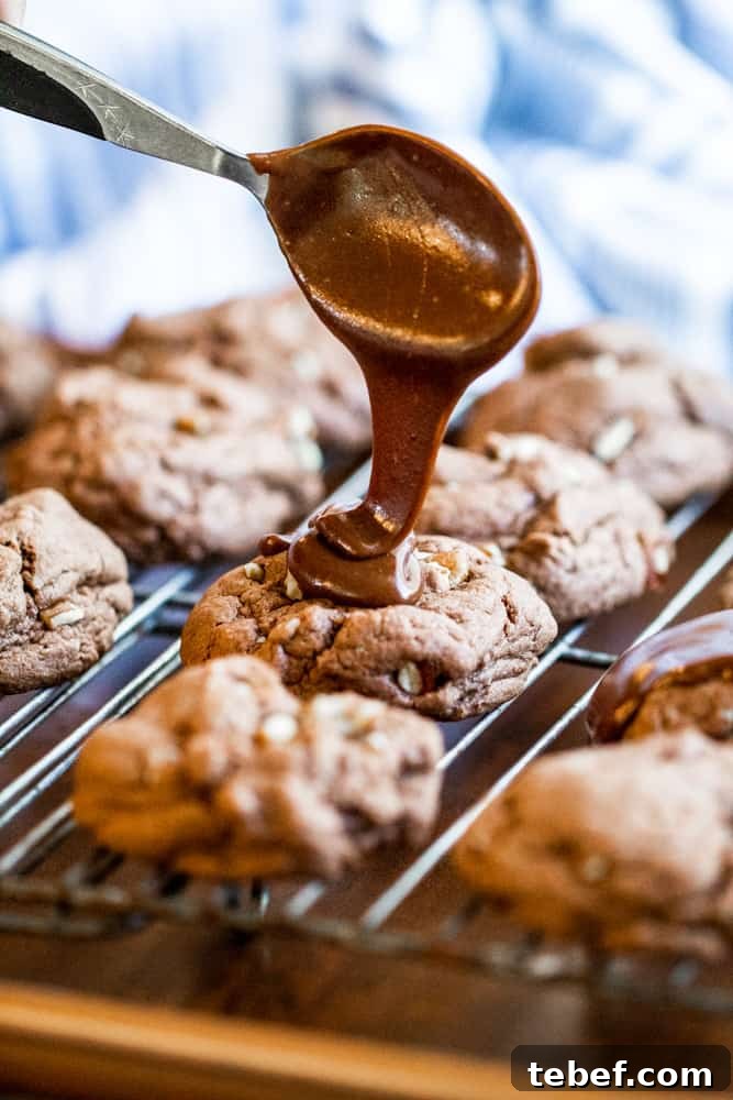 Spoon drizzle cookie with chocolate icing on a cooling rack.