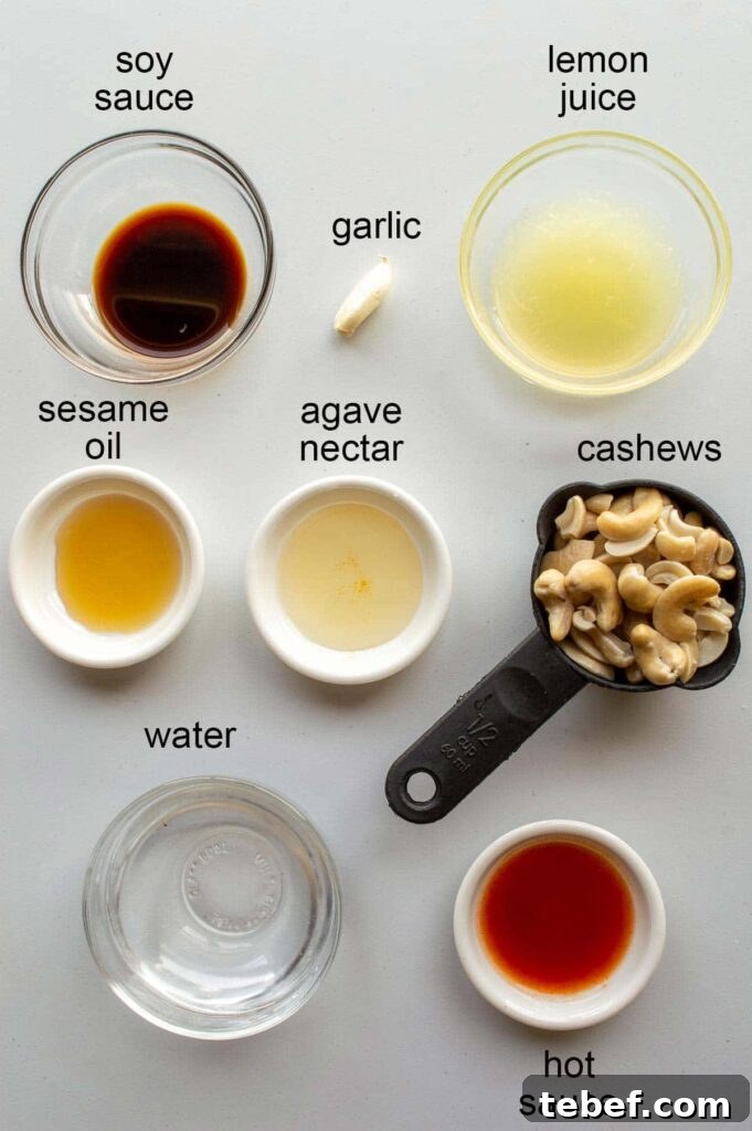 ingredients for the recipe, shot from above and labelled: soy sauce, garlic, lemon juice, sesame oil, agave nectar, cashews, water, and hot sauce.